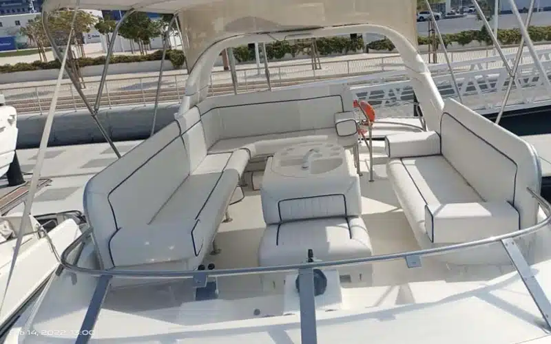 كابينة مريحة داخل Sun Rise Yacht تتميز بسرير مزدوج وألواح خشبية وإضاءة محيطة لشروق الشمس من خلال نوافذ الكوة