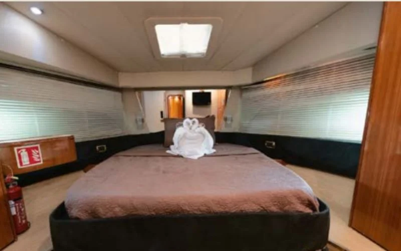 غرفة نوم فاخرة على متن يخت إيتوشا مع ديكور أنيق وإضاءة محيطة - تقدم مالا لليخوت خدمة تأجير يخوت فاخرة في دبي للإقامة الليلية بأناقة.