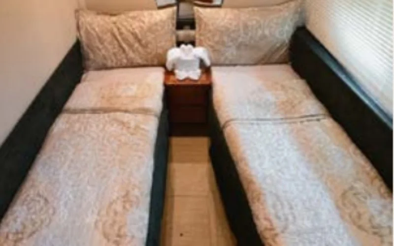 غرفة نوم مزدوجة فسيحة على متن يخت إيتوشا الذي يتميز بأسرّة مزدوجة وتصميم عصري - استمتع باستئجار يخت مريح وأنيق في دبي مع مالا لليخوت.