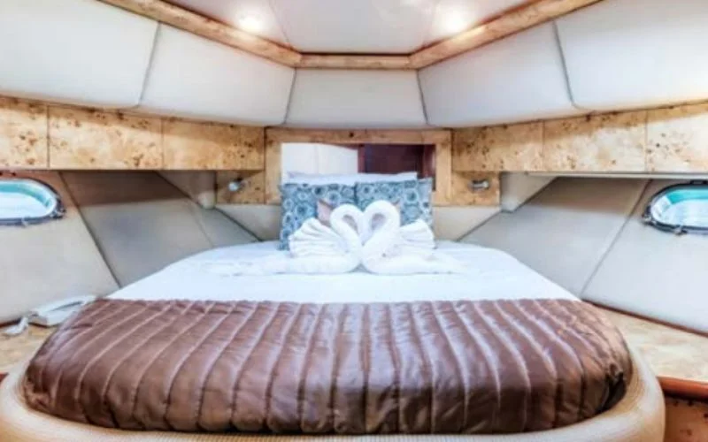 غرفة نوم أنيقة وفسيحة داخل يخت سيلفر كريك مع إضاءة خافتة وديكور راقٍ - استمتع بالاسترخاء المطلق مع يخت مالا لليخوت الفاخرة المستأجرة في دبي.