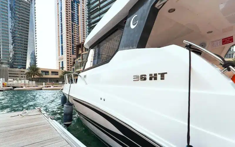 يخت الرعد الذي يبحر على طول ساحل دبي مع أفق دبي في الخلفية - تقدم مالا لليخوت خدمة تأجير يخوت فاخرة في دبي لقضاء لحظات لا تُنسى على الماء.