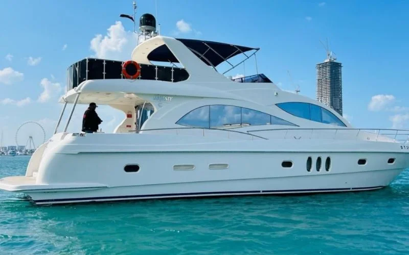 Side view of Majesty 77ft Yacht sailing through calm waters with sleek white structure