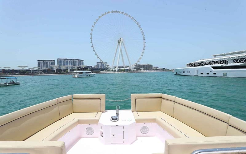 Open-air deck on Cooler Bird Yacht featuring cushioned seating, teak flooring, and panoramic ocean views—ideal for sunset lounging