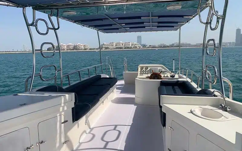 Main salon of catamaran featuring open-plan lounge and dining setup, upholstered seating, glossy wood accents, and ocean‑facing windows