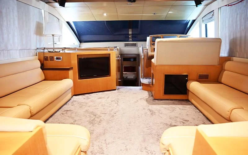 Cozy lounge area on Maze Yacht with L-shaped sofa, soft lighting, and entertainment system