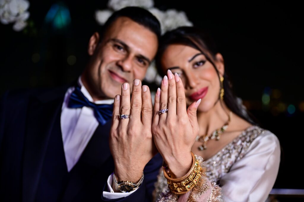 Couple smiling and displaying their wedding rings, capturing a joyful moment from a Weddings Yacht Charter provided by Mala Yachts in Dubai.