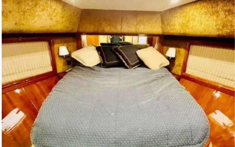 Cozy bedroom inside the Majesty 70ft yacht featuring a double bed, soft ambient lighting, and marine-inspired décor – indulge in restful luxury with Mala Yachts’ yacht rental in Dubai.