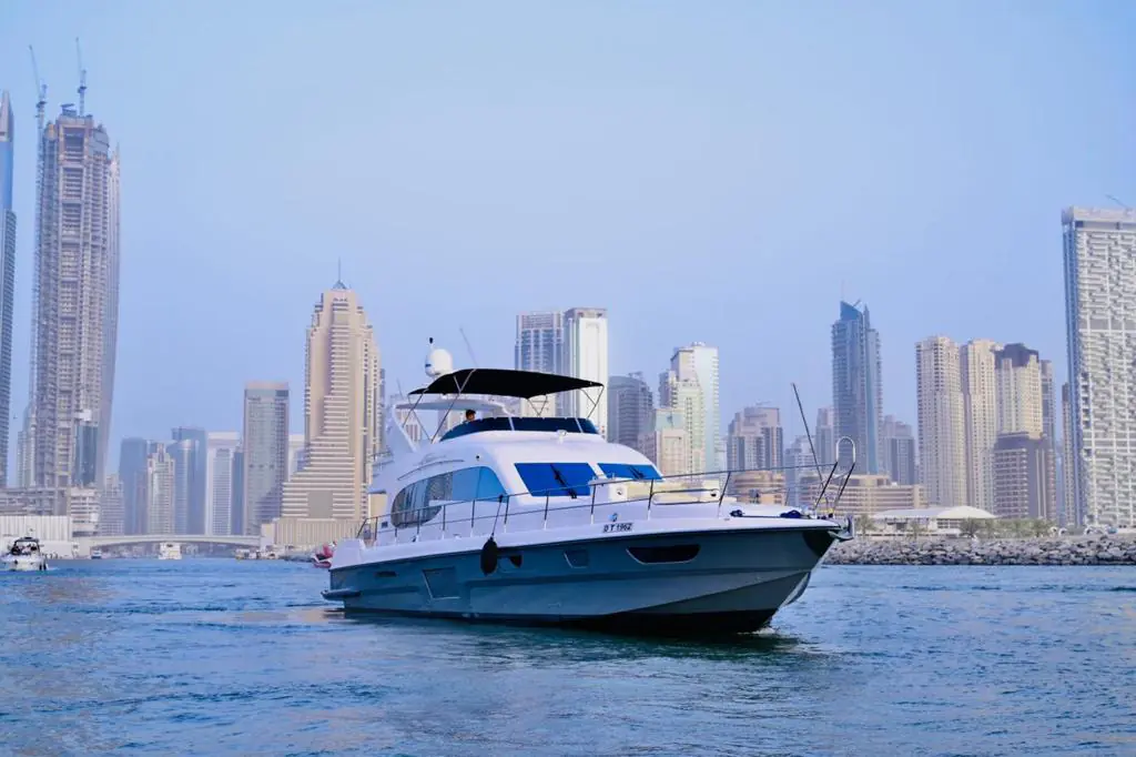 Luxury yacht cruising in Dubai with modern city skyline and calm waters