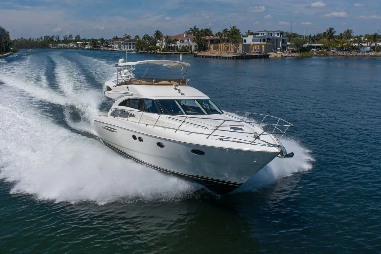 Luxury motor yacht speeding across open water with powerful wake trails