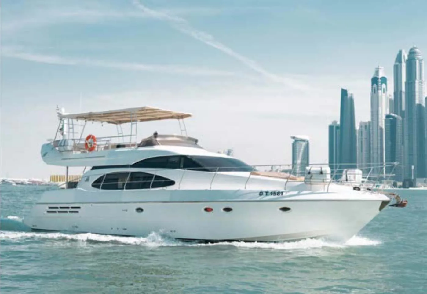 Luxury motor yacht cruising in Dubai Marina with modern skyline and clear waters