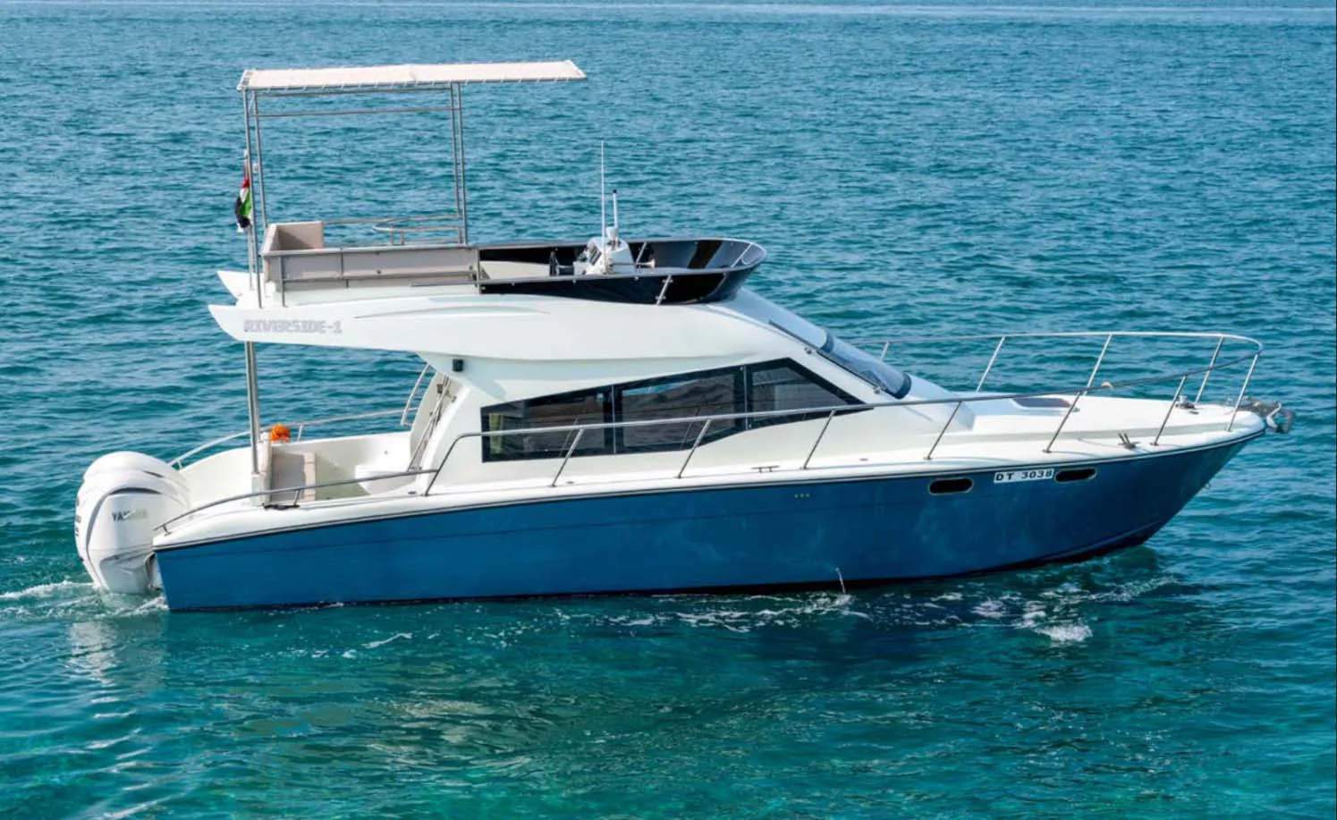 Luxury motor yacht cruising on open sea with sleek blue-and-white design