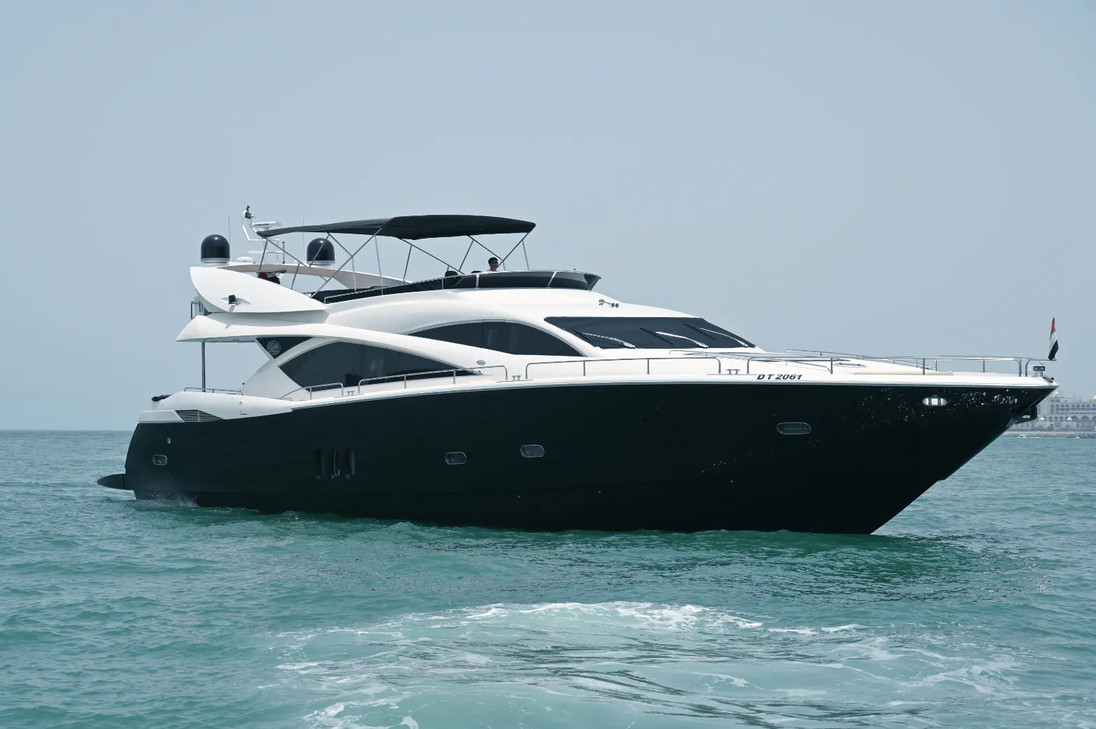 Luxury black-and-white motor yacht cruising on open water with a sleek modern design.