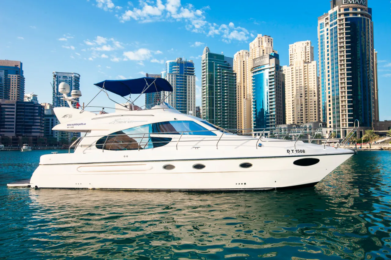 Luxury yacht cruising in Dubai Marina with high-rise skyline and calm waters