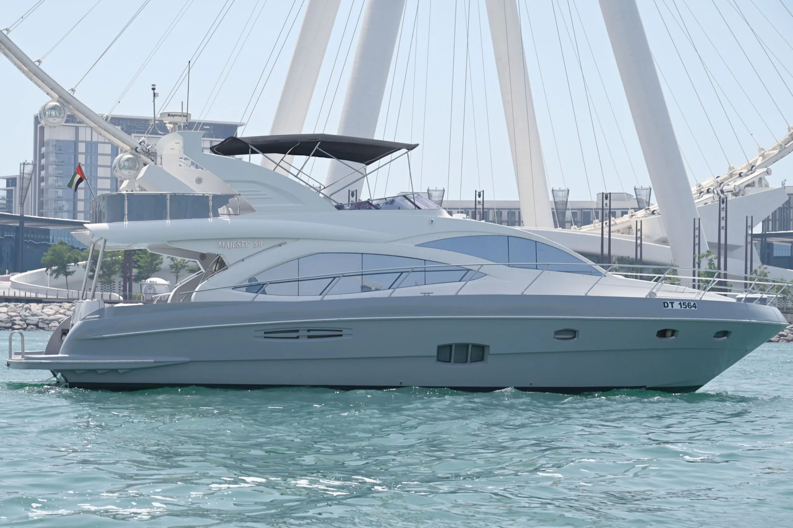 Luxury motor yacht docked near Ain Dubai with calm turquoise waters