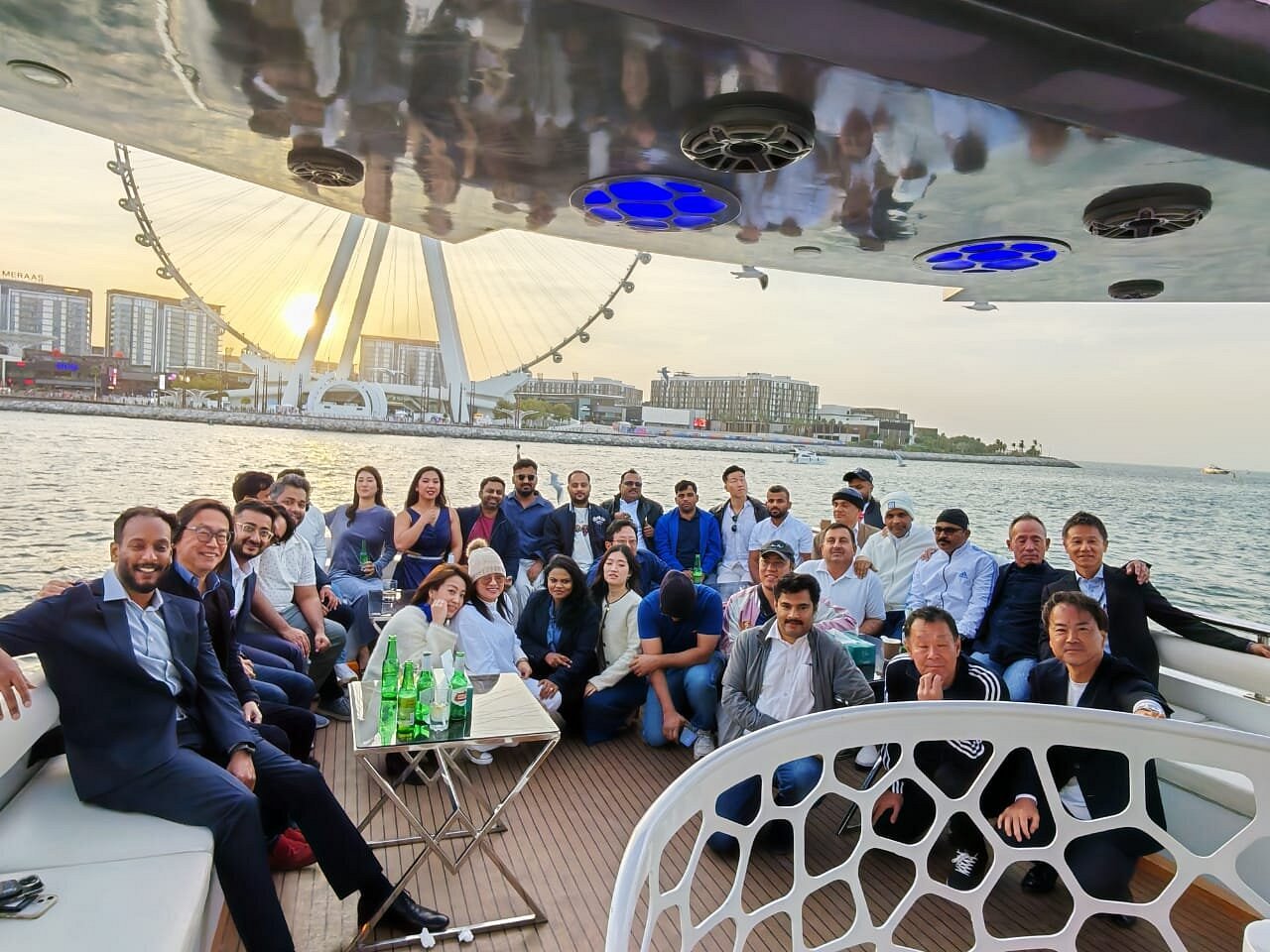 Majid Al Futtaim colleagues seated together on the yacht deck at sunset during the award celebration